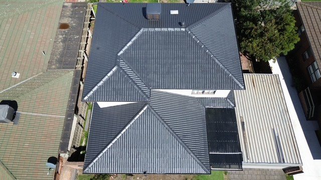 After: roof restoration. Moss and lichen gone, the whole roof coated charcoal.