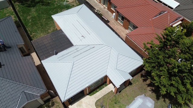 After: roof restoration. An old red concrete roof brought back in a light grey.