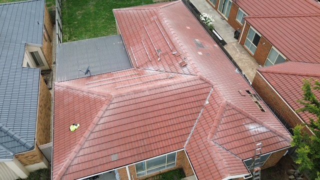 Before: roof restoration. An old red concrete roof brought back in a light grey.