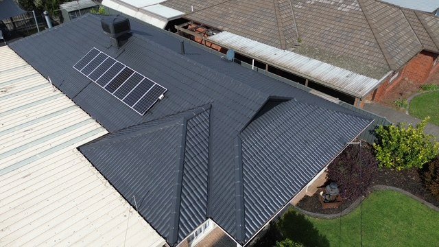 After: roof restoration. A tired brown tile roof restored to charcoal.