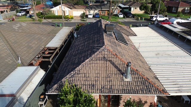 Before: roof restoration. A tired brown tile roof restored to charcoal.