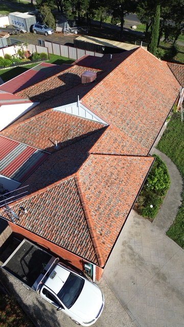 Before: roof restoration. Faded terracotta restored in fresh terracotta.