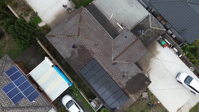 Before: roof restoration. Brown tiles restored to charcoal.