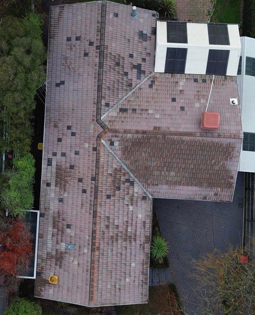 Before: roof restoration. Patchy, mismatched tiles finished in one colour.