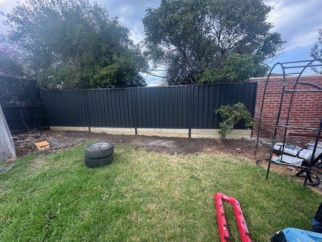 A new steel panel fence across a backyard