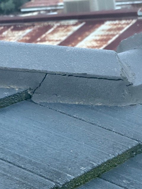 A cracked roof tile found during a roof inspection